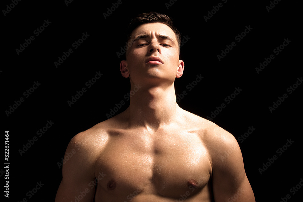 Handsome wet sport sexy stripped guy portrait with waterdrops and smoke on isolated black background Handsome wet sport sexy stripped guy portrait with waterdrops and smoke on isolated black background