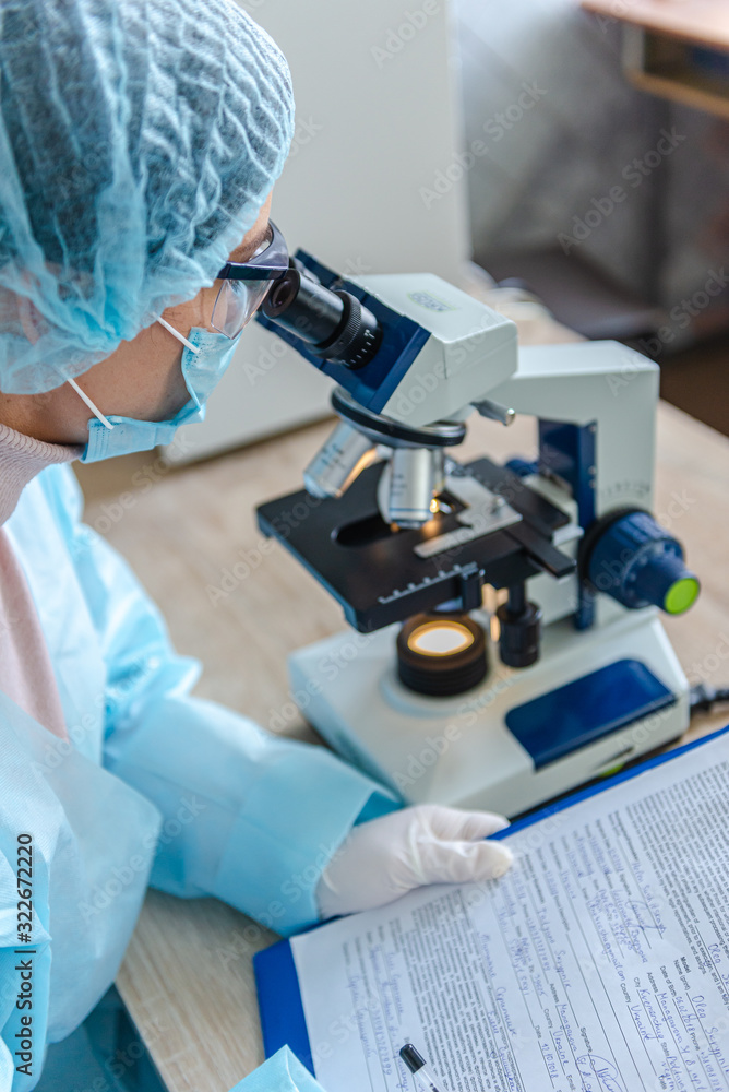 Female scientist studying coronavirus. The doctor looks through a microscope at a vaccine against coronavirus. Female scientist studying coronavirus. The doctor looks through a microscope at a vaccine against coronavirus.