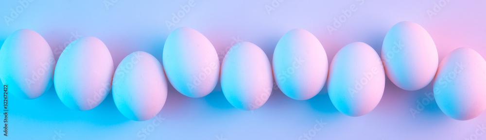 Holographic futuristic chicken eggs lit with blue and pink neon lights Holographic futuristic chicken eggs lit with blue and pink neon lights