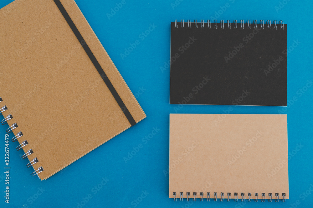 group of minimalist looking notebooks of different shapes on blue group of minimalist looking notebooks of different shapes on blue