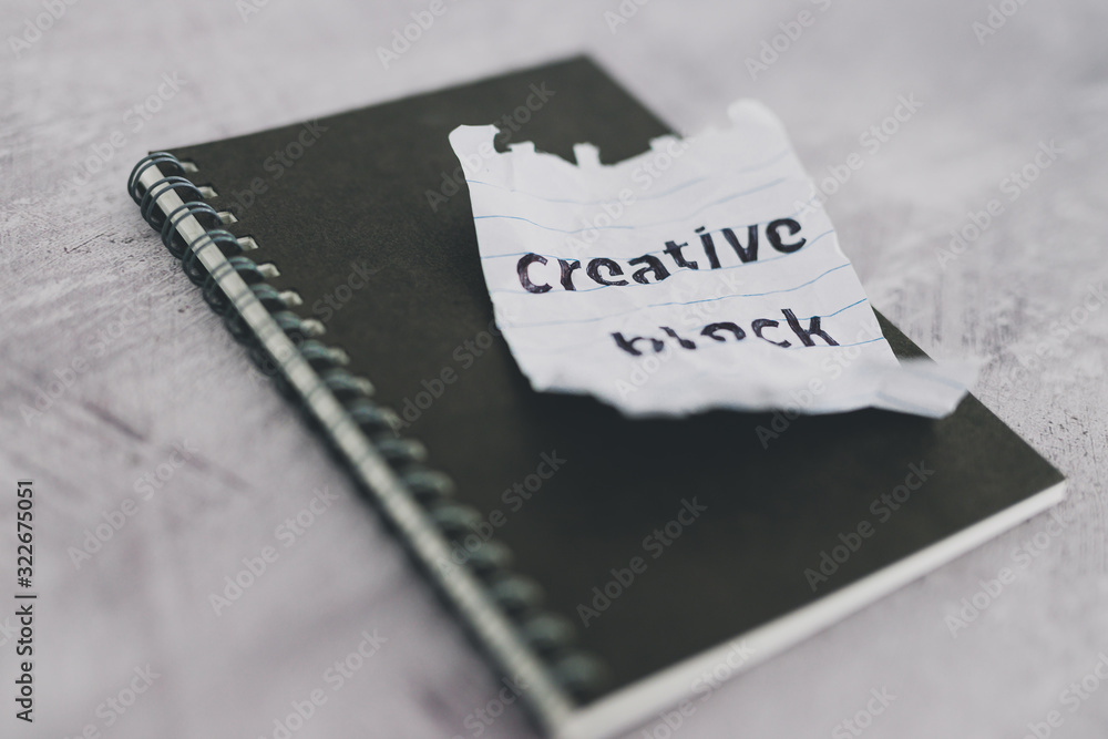 scrunched paper with Creative Block text on desk with notepad, lack of inspiration scrunched paper with Creative Block text on desk with notepad, lack of inspiration