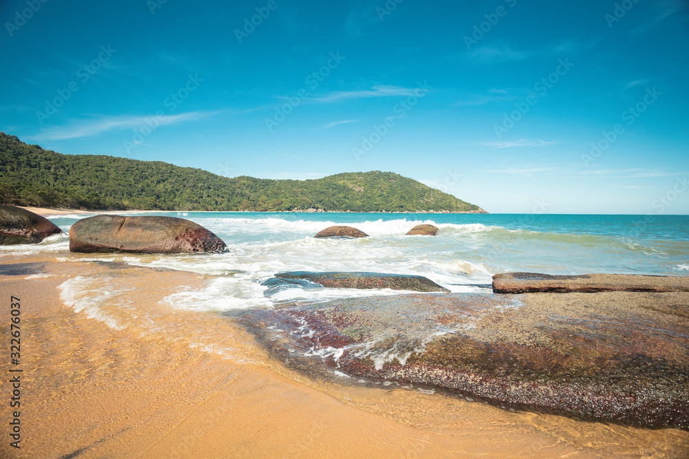 Beautiful Parnaioca beach with crystal blue water and stones, deserted tropical beach on the sunny coast of Rio de Janeiro, Ilha Grande in the city of Agnra dos Reis, Brazil