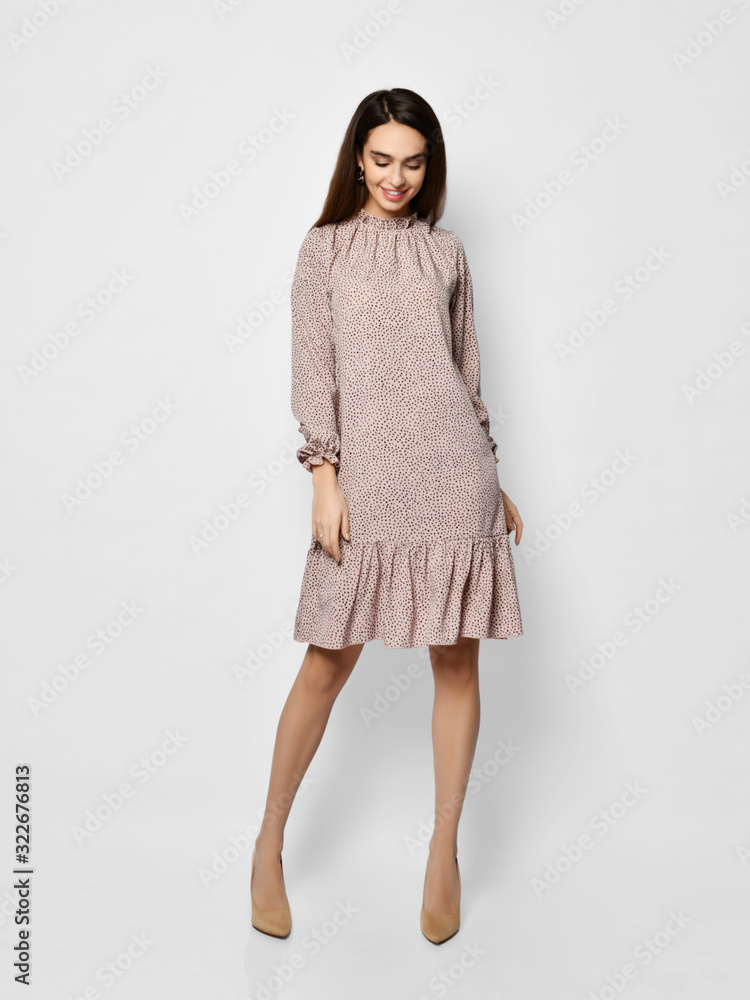 Young beautiful woman posing in new fashion long casual pastel pink color dress happy smiling walking on white Young beautiful woman posing in new fashion long casual pastel pink color dress happy smiling walking on white