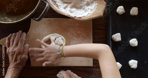 Top view preparing food. Cooking With Grandma. Beautiful Little Girl Learns How To Make Cookies.