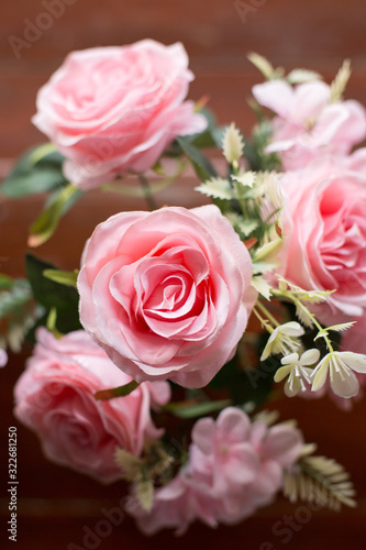 Beautiful pink roses on the old wooden table background