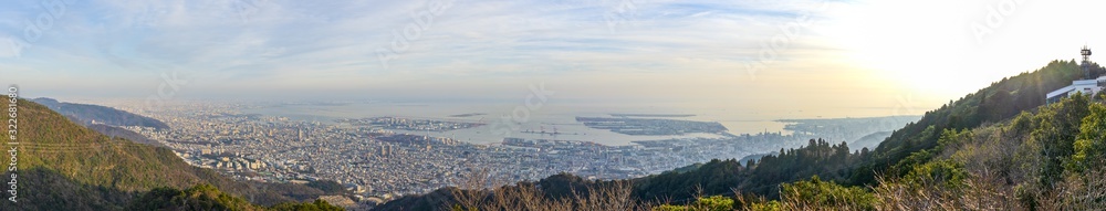 Kobe city panoramic view from Mt. Maya Kikusedai park observatory platform in sunny day sunset time with blue sky background, famous by the 10 ten million dollar night views. Hyogo Prefecture, Japan