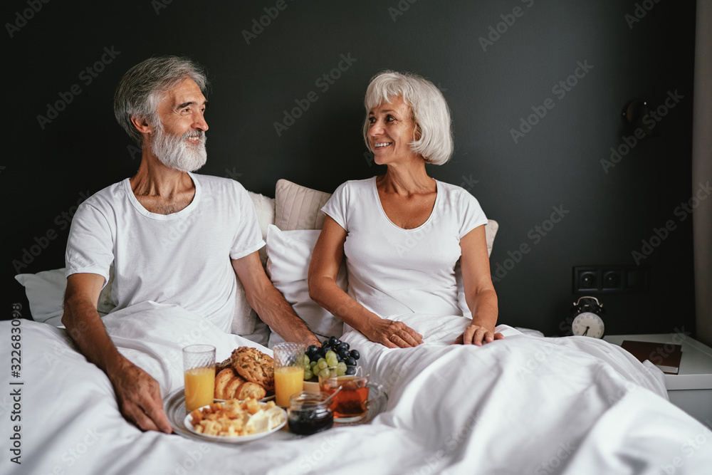 Good morning! Senior family couple enjoying breakfast in bed. Good morning! Senior family couple enjoying breakfast in bed.