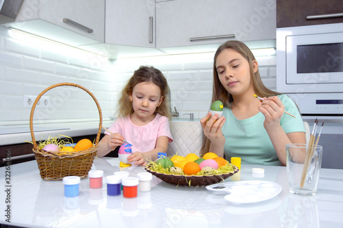 Happy easter. Two sisters painting Easter eggs. Happy family children preparing for Easter. Cute little child girl wearing bunny ears on Easter day.