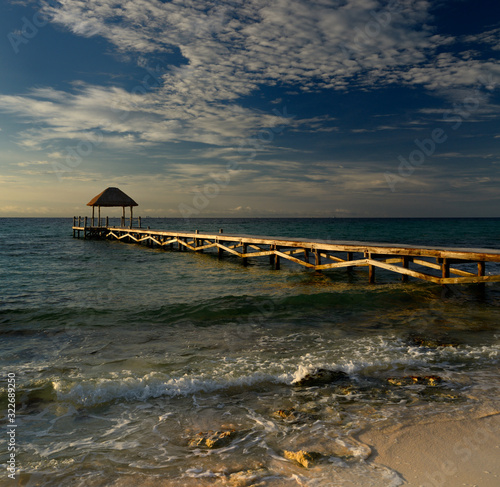 Thatched roof gazebo on the end of a dock on the Mayan Riviera at dawn