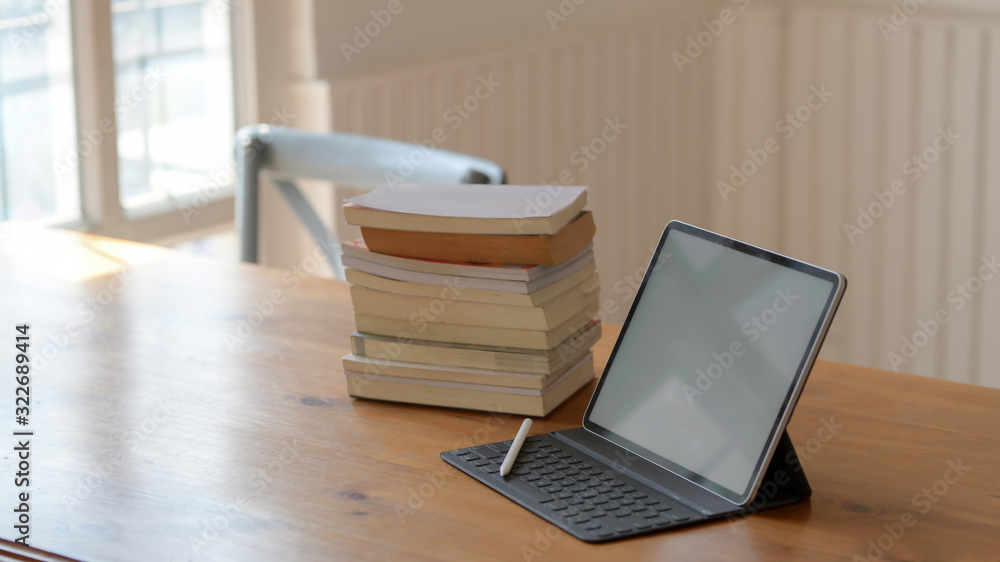 Cropped shot of blank screen tablet and books on wooden table Cropped shot of blank screen tablet and books on wooden table