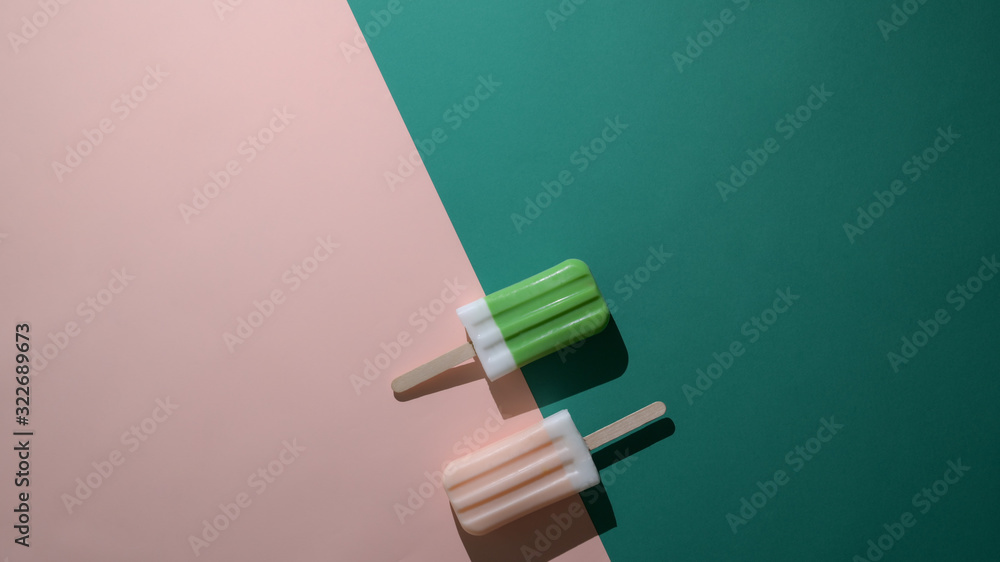 Overhead shot of green tea and strawberry flavour popsicles and copy space on flat lay green and pink background Overhead shot of green tea and strawberry flavour popsicles and copy space on flat lay green and pink background