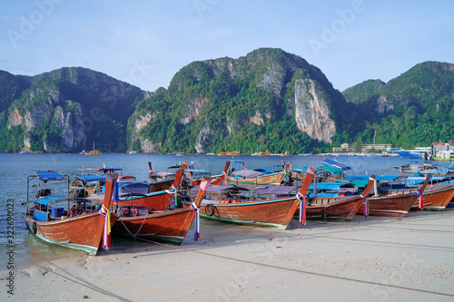 Beautiful landscape with traditional longtail boats, rocks, cliffs, tropical beach. Phi Phi Don Island, Thailand.