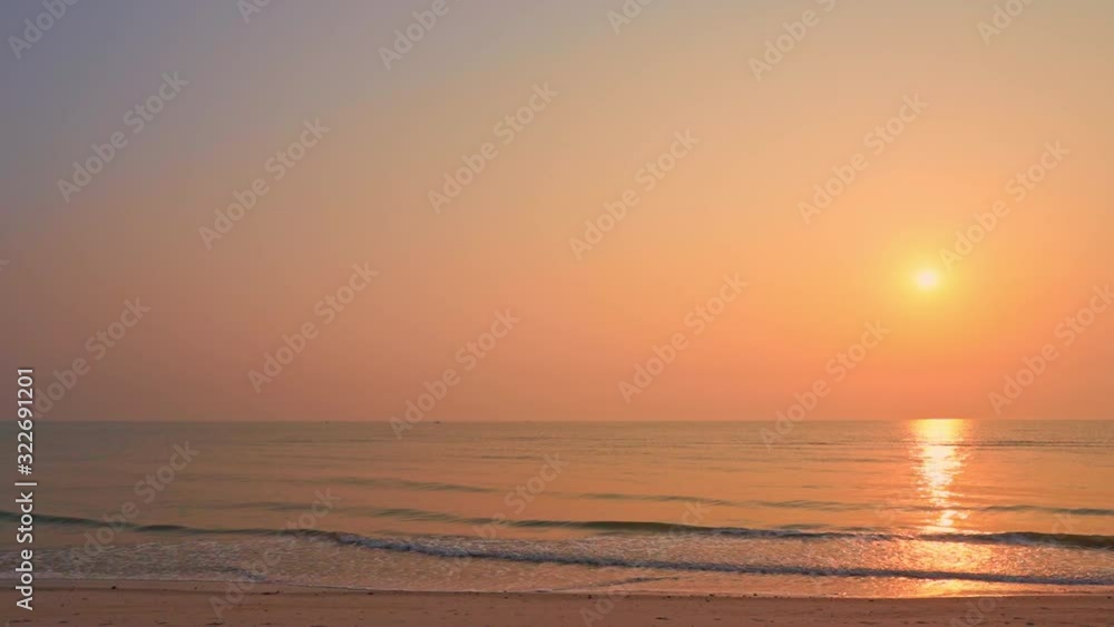 Slow pan to the left of a dramatic pink and orange sunset over the ocean waves. Slow pan to the left of a dramatic pink and orange sunset over the ocean waves.