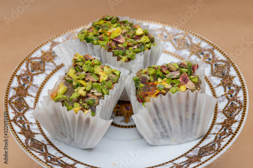 Three slices of fruit and nut pistachio lokum on a saucer, a tra