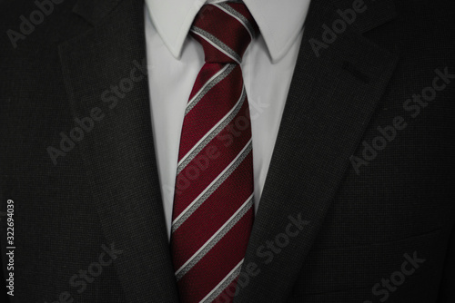 Man in grey suit with red and white tie