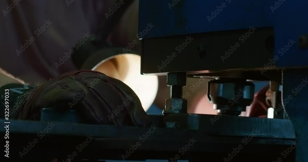 Close-up of a worker using the iron punching machine. Close-up of a worker using the iron punching machine.