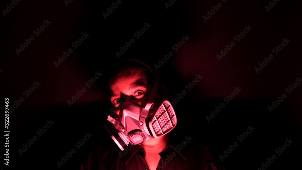 Coronavirus pathogen outbreak pandemic concept. Woman in urban protective or medical mask, looking at the camera on black background. Virus disease 2019-nCoV protection and prevention.