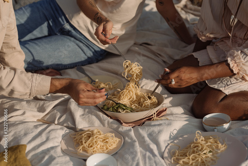 three people eating pasta