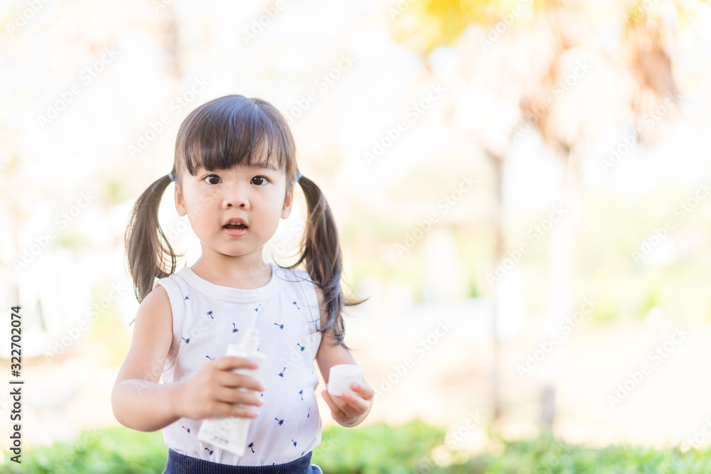 Adorable toddler girl putting solar cream on arms hands Smiling happy outdoors by pool under sunshine on beautiful summer day.Mixed race Asian / Caucasian kid girl.Sunscreen or sunblock and Skincare. Adorable toddler girl putting solar cream on arms hands Smiling happy outdoors by pool under sunshine on beautiful summer day.Mixed race Asian / Caucasian kid girl.Sunscreen or sunblock and Skincare.