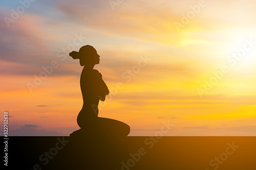 Silhouette of young woman with clipping path practicing yoga relaxing exercise at sunset