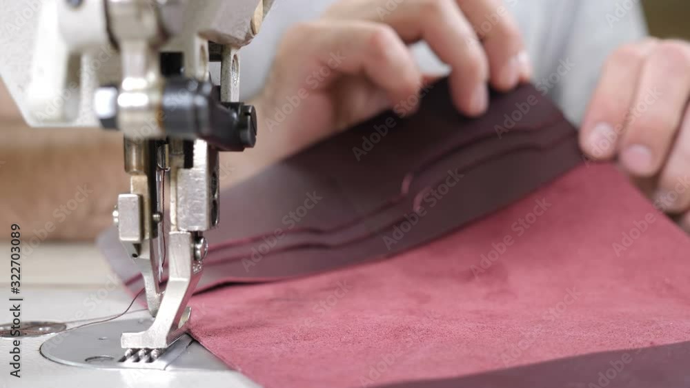 Craft leather workshop and manufacture. Close-up of master sewing pieces of leather, stitches straps and stitches marked out brushes into bag. Craft factory authentic. 4 k Craft leather workshop and manufacture. Close-up of master sewing pieces of leather, stitches straps and stitches marked out brushes into bag. Craft factory authentic. 4 k
