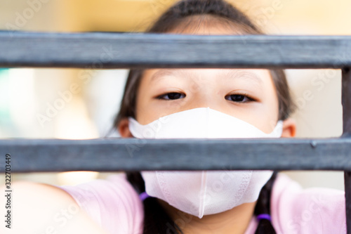 Coronavirus and Air pollution pm2.5 concept.Little chinese girl wearing mask for protect pm2.5.Kid girl imprison at home for protection corona virus.Wuhan coronavirus and epidemic virus symptoms.