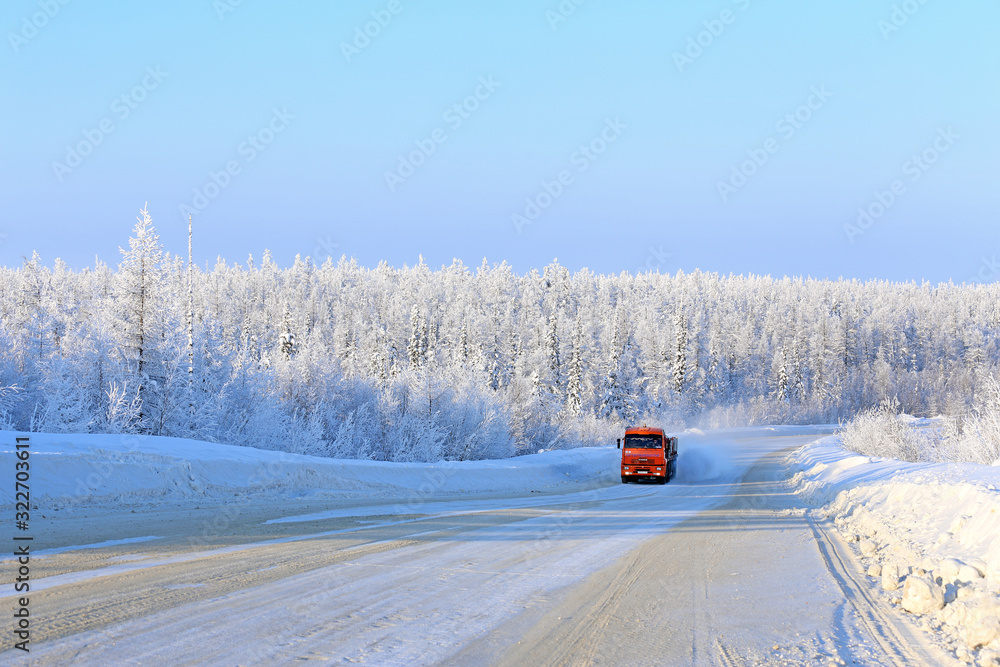 Truck on a winter road in the snow-covered taiga of Siberia Truck on a winter road in the snow-covered taiga of Siberia