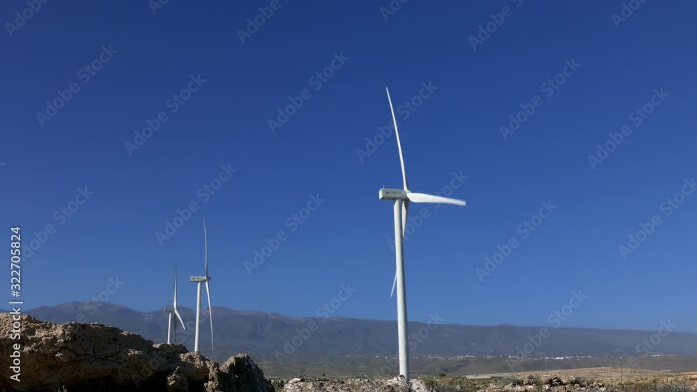 Wind turbines. Side view on a background of mountains. Tenerife, Canary Islands. Wind turbines. Side view on a background of mountains. Tenerife, Canary Islands.