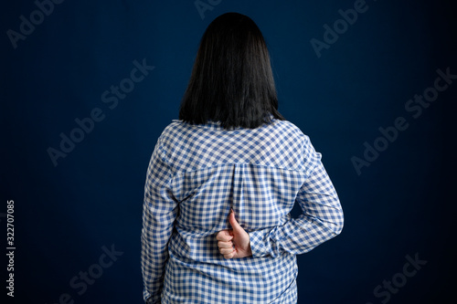 Young woman dressed casually showing thums up behind him photo