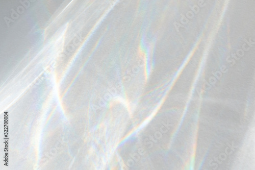 Water texture overlay effect for photo and mockups. Organic drop diagonal shadow caustic effect with rainbow refraction of light on a white wall.