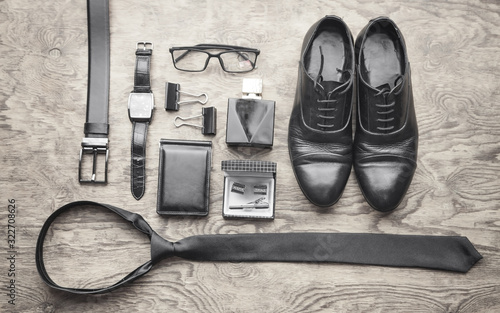 Tie, wristwatch, perfume, belt, wallet, shoes on the black background. Men accessories