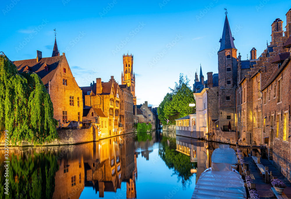 Naklejka premium Panoramę miasta Brugii z kanałem w nocy w Belgii
