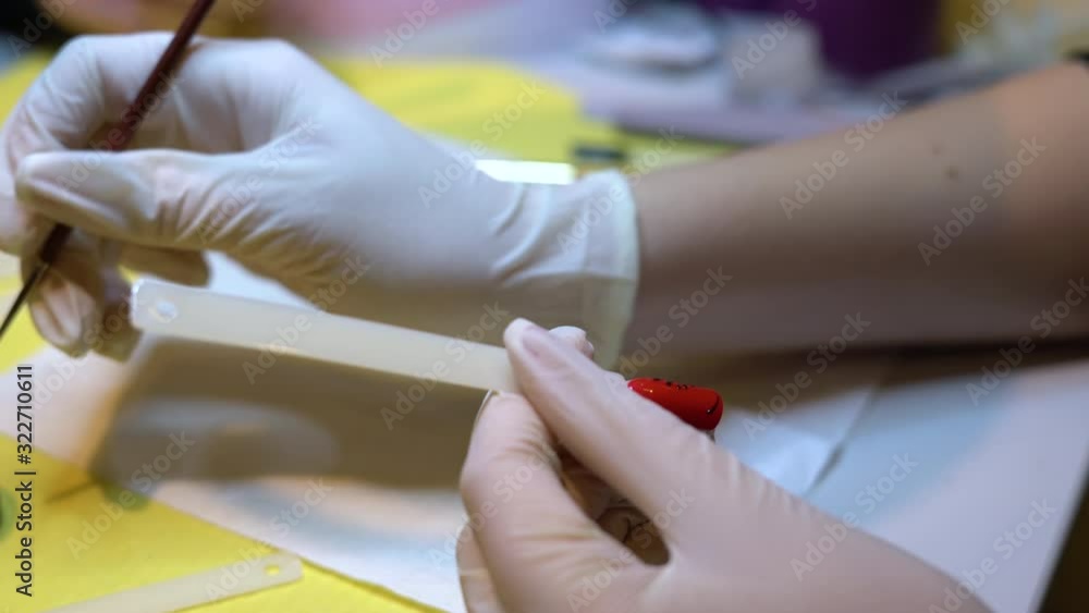 Close up of woman paint on nail with a brush. Painting on gel nail extensions, nail art Close up of woman paint on nail with a brush. Painting on gel nail extensions, nail art