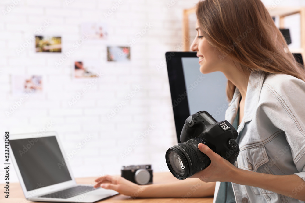 Professional photographer with camera working at table in office