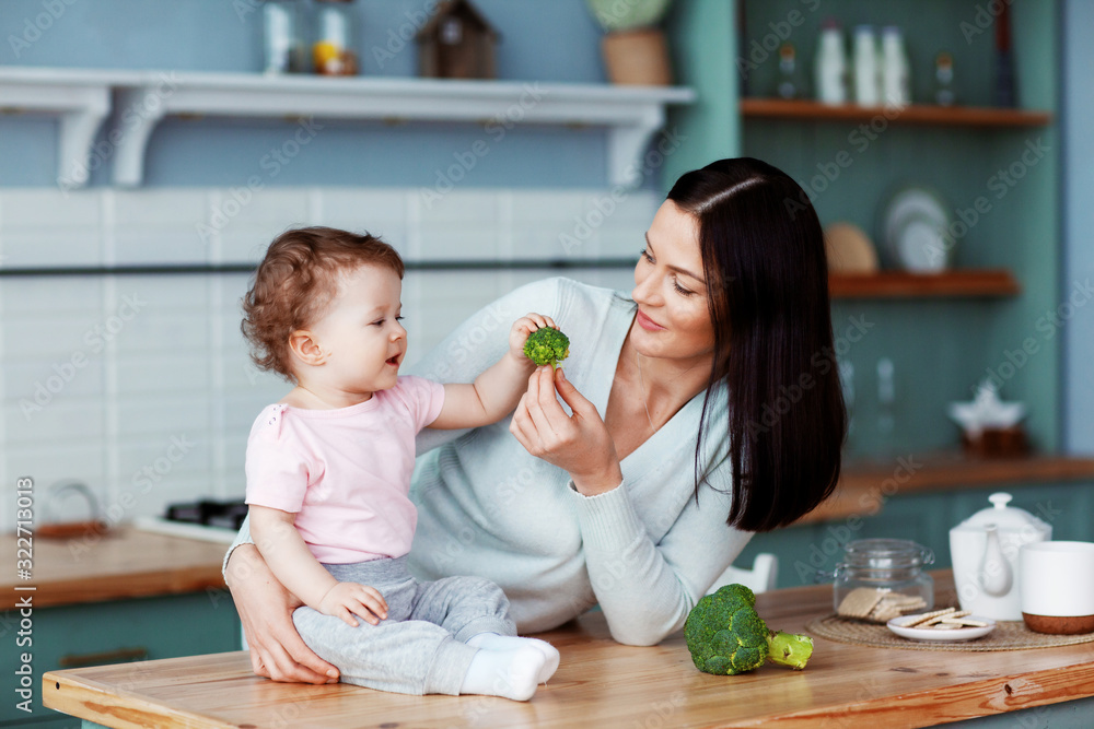 Mother feeds baby broccoli and vegetables. Proper and healthy nutrition Mother feeds baby broccoli and vegetables. Proper and healthy nutrition