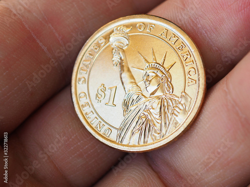 American coin lies on the palm. 1 dollar coin close up. News about the national currency, the state budget, the Fed, inflation and the refinancing rate. The Statue of Liberty. Macro