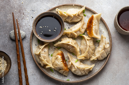 Traditional japaneese gyoza dumplings with meat and mushrooms on ceramic plate photo