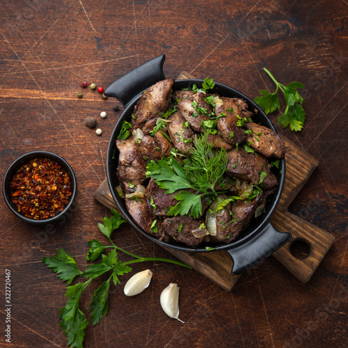 fried chicken liver with onion and herbs in black pot