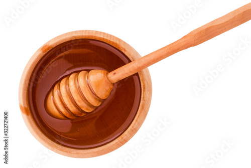 Bee honey with wooden dipper stick and plate isolated on white background, clipping path, top view.