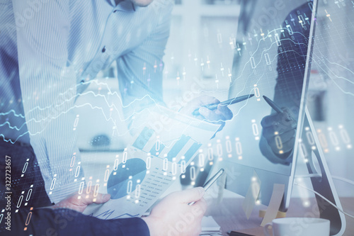 Double exposure of chart with businessman typing on computer in office on background. Concept of hard work.