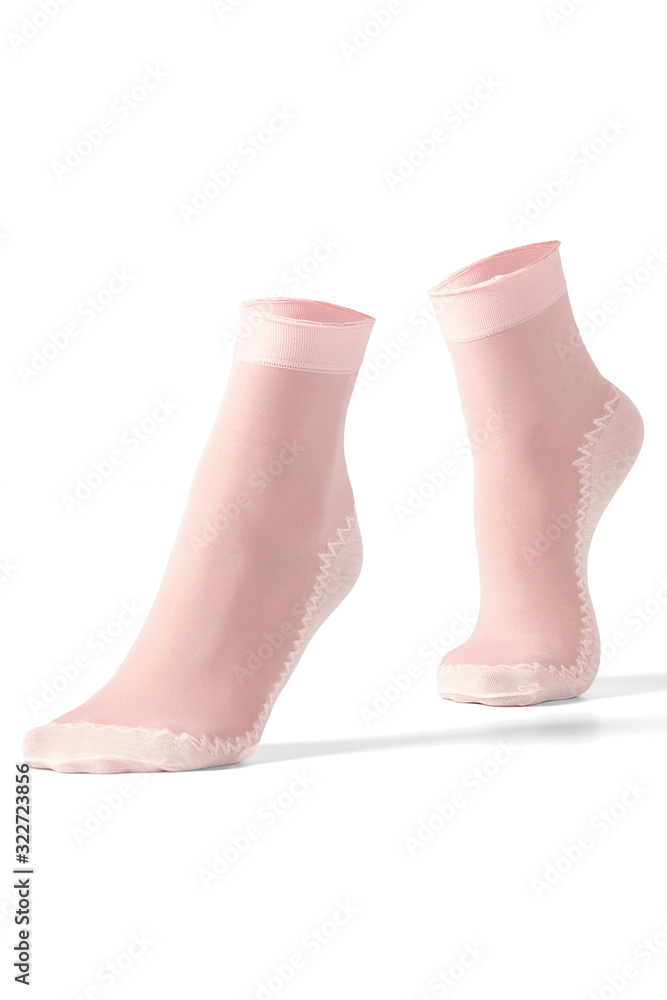 Cropped shot of female feet on tiptoe in pink nylon socks with white reinforced bottoms, toes, rims and zigzag stripe. The photo is made on the white background. Cropped shot of female feet on tiptoe in pink nylon socks with white reinforced bottoms, toes, rims and zigzag stripe. The photo is made on the white background.