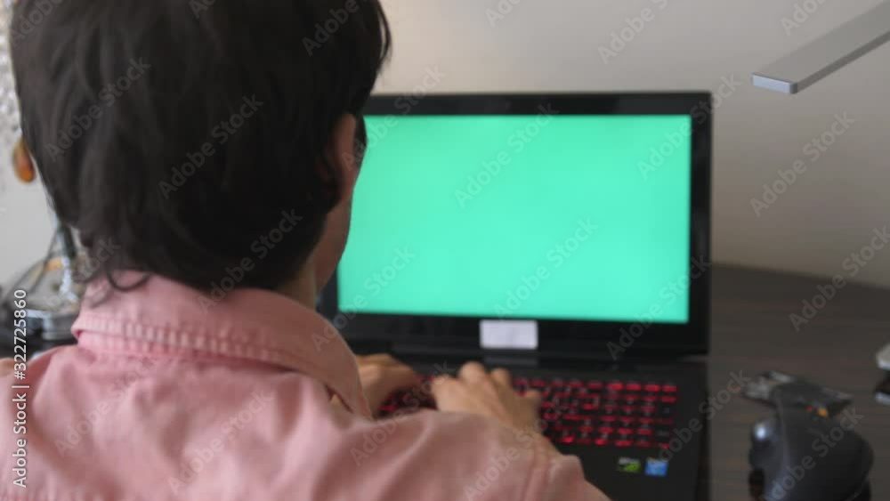 Man works on the laptop with a green screen Man works on the laptop with a green screen