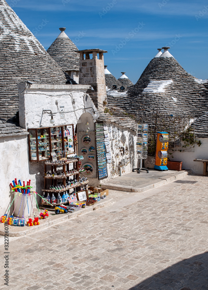  Souvenir shop in traditional white trulli house with conical roofs and painted symbols in Alberobello, Apulia, Italy