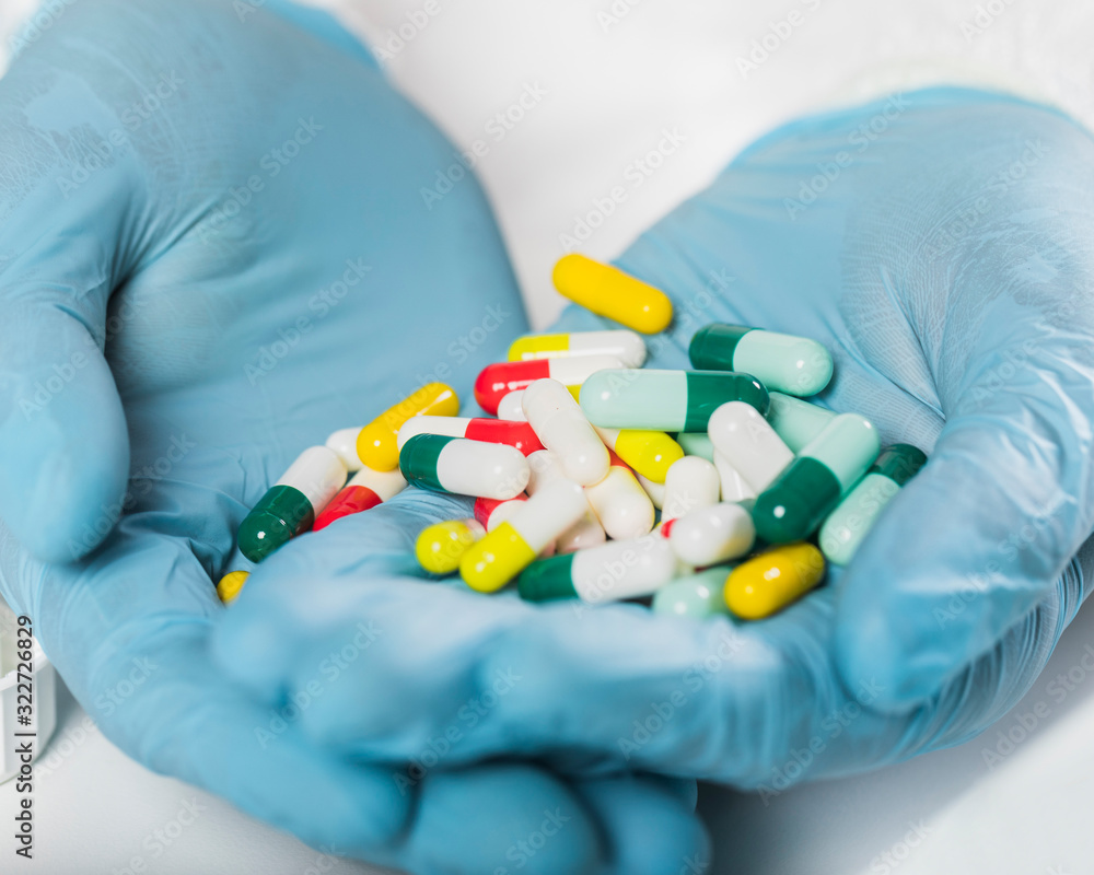 Close-up hands holding variety of colorful capsules Close-up hands holding variety of colorful capsules