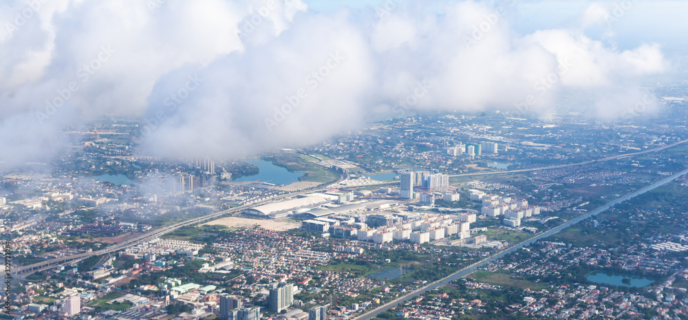 Bird Eye or Aerial View from plane window: Bangkok Cityscape on a sunny day. Air Transportation, Travel, Landscape, Urbanization, City Plan, Real Estate and Asian Capital City Development concept