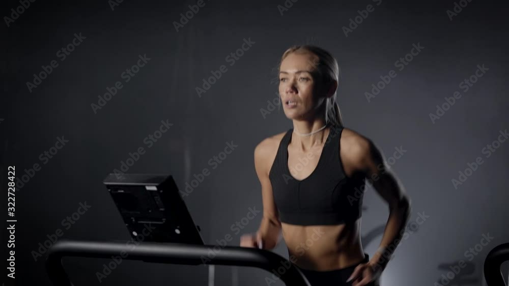 sexy young woman is jogging on moving walk in fitness club, training her endurance, cardio workout sexy young woman is jogging on moving walk in fitness club, training her endurance, cardio workout