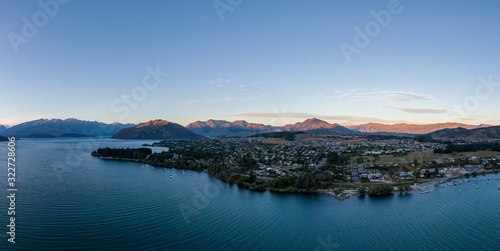 Fototapeta Naklejka Na Ścianę i Meble -  XXL panoramic evening sunset high angle aerial drone view of the town of Wanaka, a popular ski and summer resort town located at Lake Wanaka in the Otago region of the South Island of New Zealand.