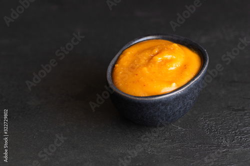 Almogrote, famous La Gomera cheese  paste, in black ceramic bowl on background. Its appetizer in many restaurants in Canary Islands made from hard cheese, peppers, olive oil and garlic