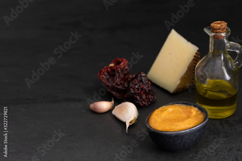 Almogrote,  La Gomera cheese paste, with their ingredients hard cheese, peppers, olive oil and garlic on black background. It is popular appetizer in many restaurants in Canary Islands