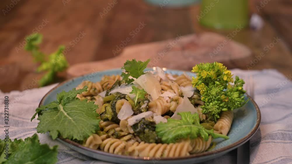 Cime di rapa pasta in a plate on with parmesan on a wooden table. Traditional food of the south of Italy, from Puglia. Rustic style photo. Copy space Cime di rapa pasta in a plate on with parmesan on a wooden table. Traditional food of the south of Italy, from Puglia. Rustic style photo. Copy space